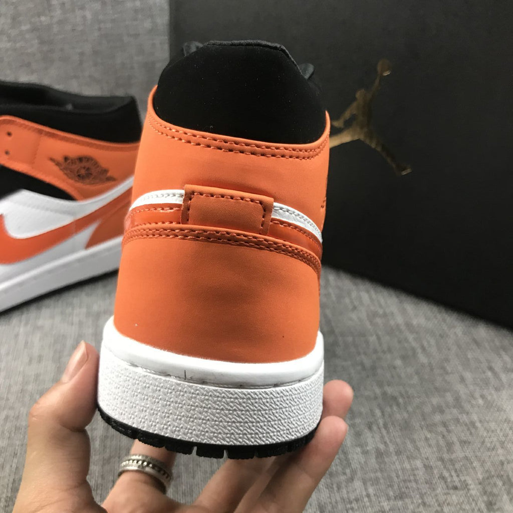 Air Jordan 1 Mid Sneakers in Black White Orange 554724-058 - product image from the listing.