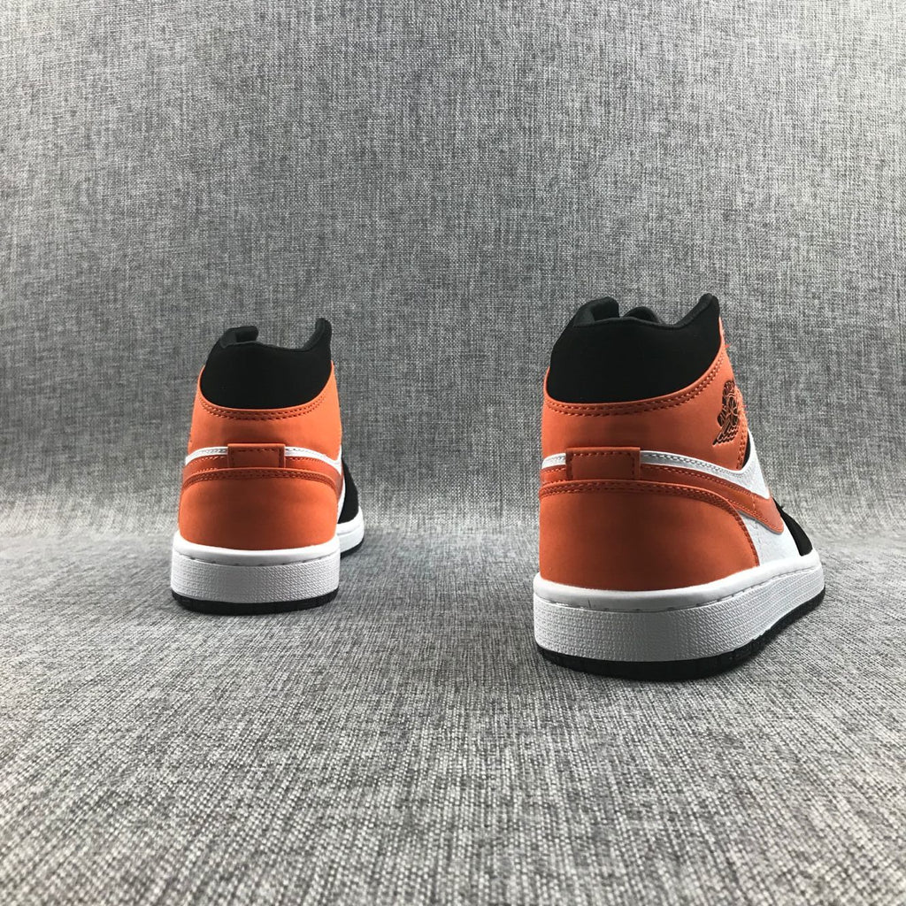 Air Jordan 1 Mid Sneakers in Black White Orange 554724-058 - product image from the listing.